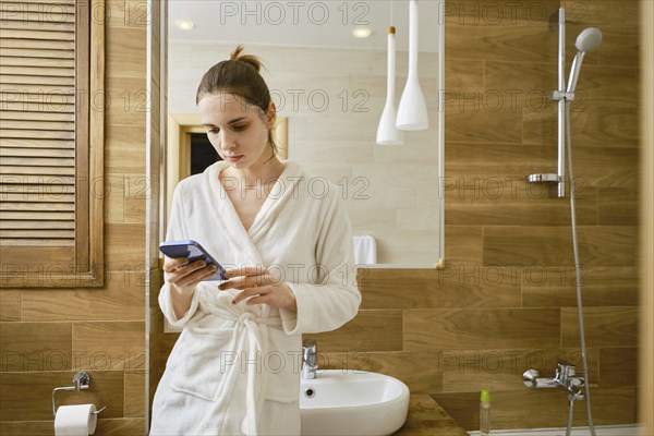A young woman applied a cosmetic fabric mask to her face and surfed the Internet to pass the time