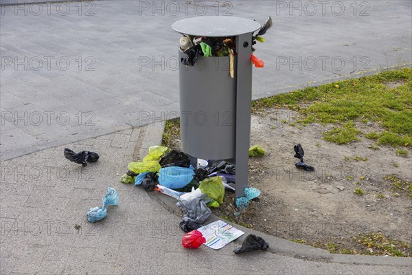Public waste bin at leipzig city harbour, completely overcrowded, pet owners throw their dog waste