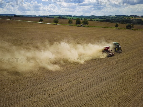A tractor with a Horsch PRONTO DC 6 seed drill sowing in a dry field in late summer., Doma, Saxony,