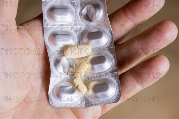 Hand holding a blister pack with tablets