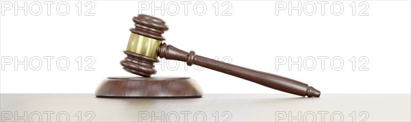 Gavel resting on a wooden table against a white background