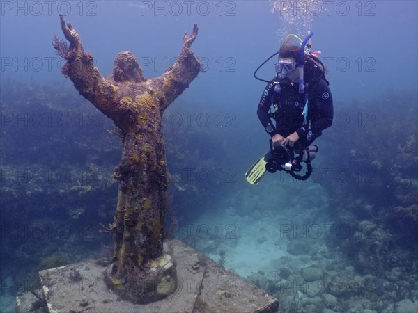 Diver looking at the statue of Jesus Christ underwater (Christ of the Abyss), dive site John