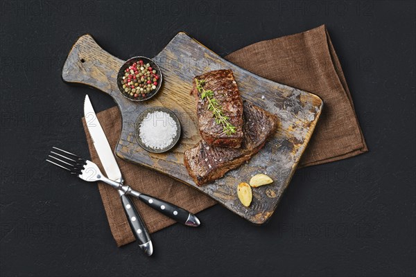Top view of pan seared beef steak on dark background