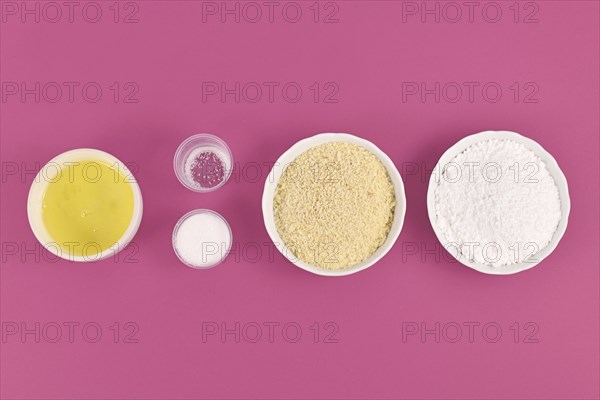 Bowls with ingredients for making homemade French Macaron sweets showing powdered sugar, ground