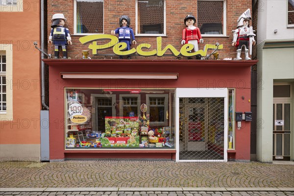 Shop window of a toy shop with oversized Playmobil figures in Warendorf, Warendorf district, North