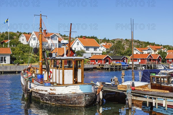Old fishing boat at a jetty in a fishing village harbour on the Swedish west coast on a sunny