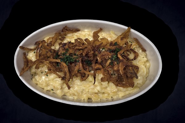 Cheese spaetzle with fried onions on a dark background, Bavaria, Germany, Europe