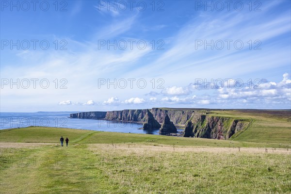 Two tourists hiking to the Duncansby Stacks on the north-eastern tip of Scotland, County Caithness,