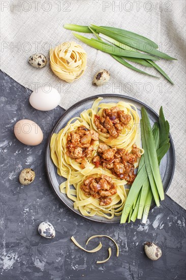Tagliatelle bolognese pasta with minced meat on a black concrete background. top view, flat lay