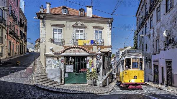A yellow tram on a cobblestone street passing by a vintage building under a clear blue sky, Alfama,