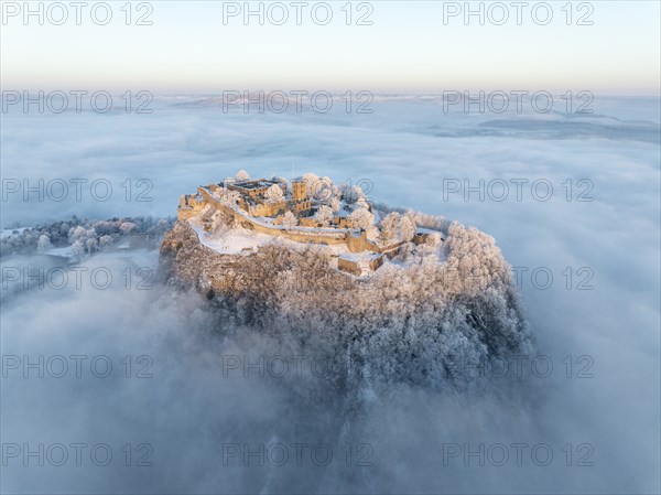 Aerial view of the Hegau volcano Hohentwiel with Germany's largest fortress ruins on a cold, foggy