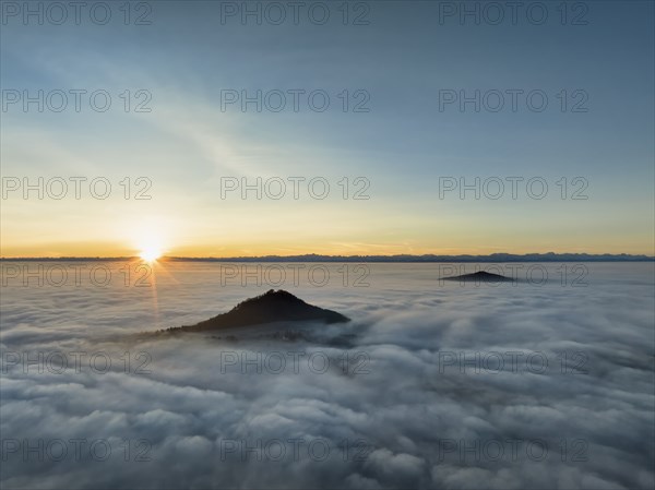 Aerial view of the wintry and fog-covered Hegaulandschaft at sunrise, the volcanic cones Hohenhewen