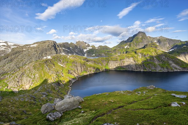 Mountain landscape with lake Tennesvatnet, at sunrise, in the back peak of Hermannsdalstinden,