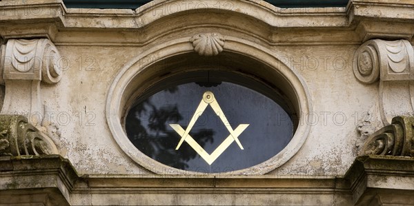 Close-up with compass and angle, two of the best-known symbols of Freemasonry on the lodge house,