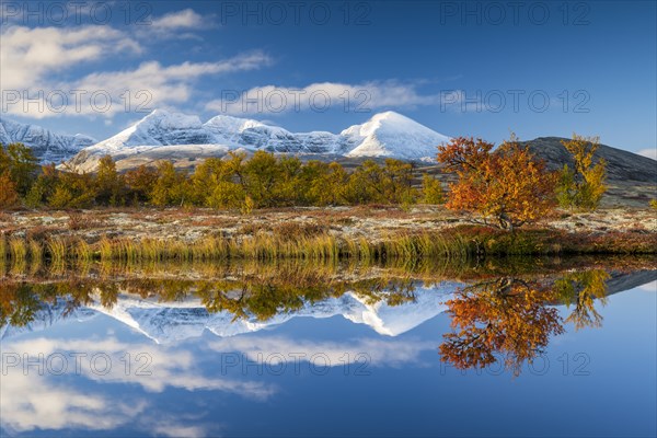 Reflection of the autumn landscape in Rondane National Park, snow-capped mountains, Doraldalen,