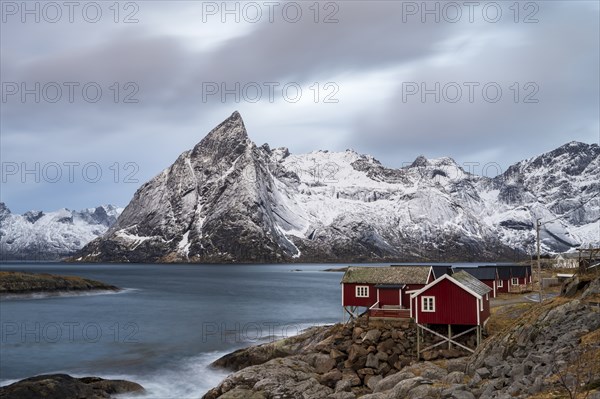 Rorbuer cabins of Hamnoy by the fjord, snowy mountains in the back, Hamnoy, Reine, Moskenesoya,