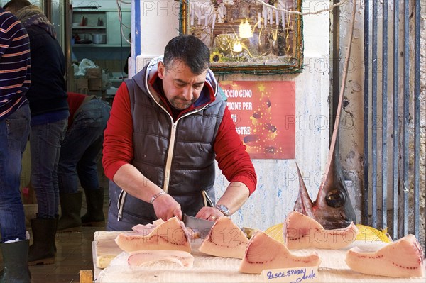 Fish seller, carving swordfish (Xiphias gladius), markets, open air, Palermo, capital, Sicily,