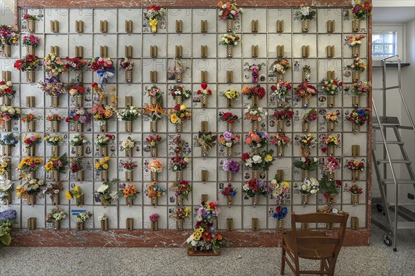 Urn graves with floral decorations in a hall at the Monumental Cemetery, Cimitero monumentale di