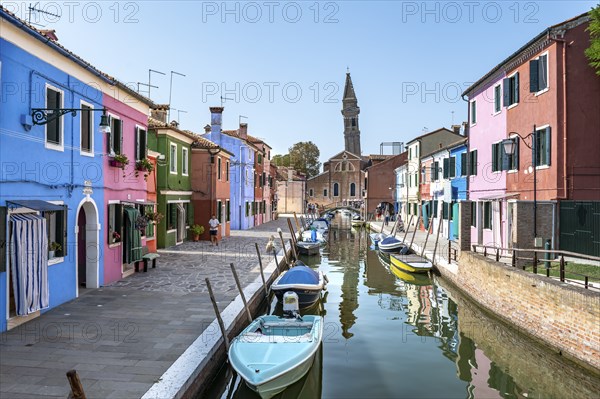Colourful houses on the canal, canal with boats and colourful house facades, behind the church