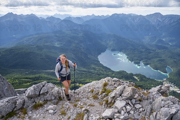 Hiker in the mountains, view of Eibsee lake and Werdenfelser Land, Wetterstein Mountains,