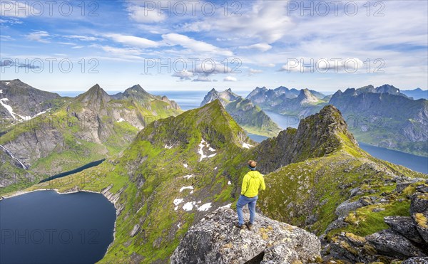 Mountaineers at the summit of Munken, mountain landscape with steep rocky mountain peaks, lake