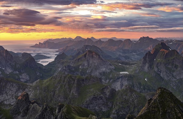 View over mountain top and sea, dramatic sunset, from the top of Hermannsdalstinden, Moskenesöy,