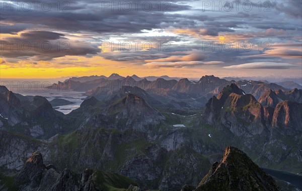 View over mountain top and sea, dramatic sunset, from the top of Hermannsdalstinden, Moskenesöy,