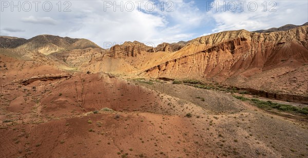 Eroded mountain landscape with sandstone cliffs, red and orange rock formations, Konorchek Canyon,