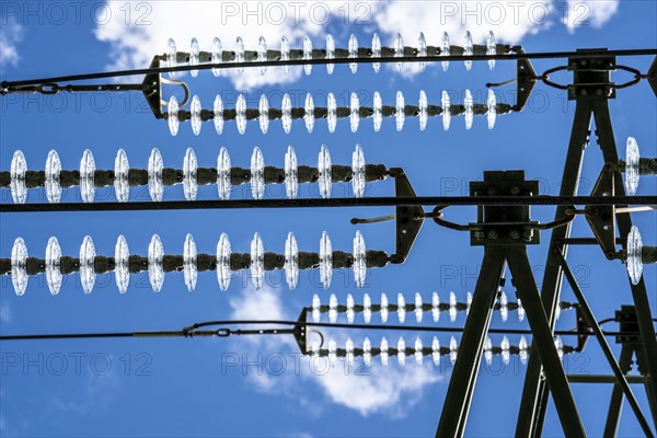 Insulators made of glass on a high-voltage line, they hang on the pylons as a suspension device