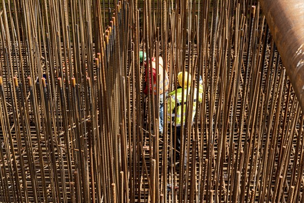 Construction site, reinforced concrete construction site, workers erect a mesh of reinforcing bars,