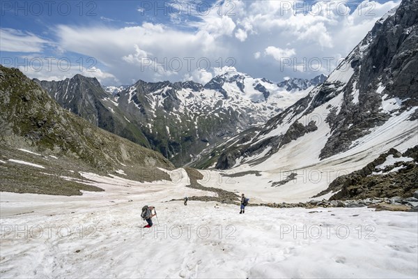 Mountaineers hiking in a snowfield, Nördliche Mörchnerscharte, behind mountain peak Kleiner