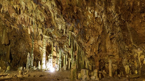Wide cave hall with illuminated stalactites and stalagmites, stalactite cave, Diros Cave, Glyafada