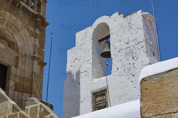 A striking bell tower made of white stones under a bright blue sky in Mediterranean architecture,