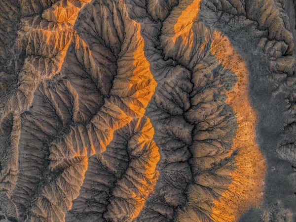 Landscape of eroded hills at Lake Issyk Kul, top-down, badlands at sunrise, aerial view, Canyon of