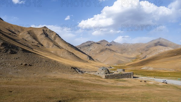 Historic caravanserai Tash Rabat from the 15th century, in the evening light with golden hills,