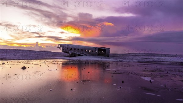 Beautiful aerial drone view at sunrise on crashed plane on frozen Solheimasandur beach in winter,