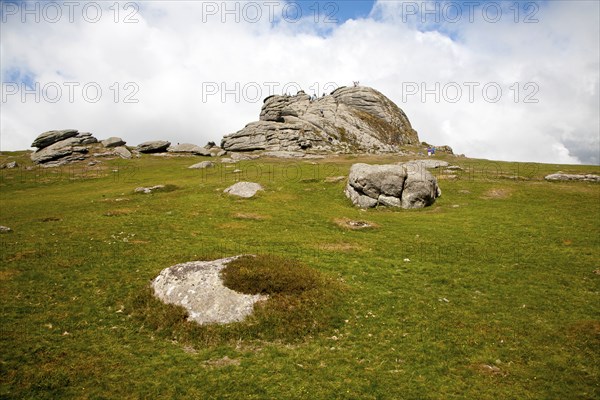 People scrambling on the granite tor of Haytor, Dartmoor national park, Devon, England, United
