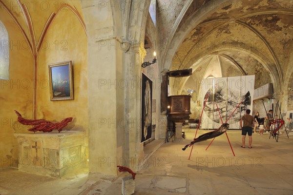 Art exhibition in the church Sainte-Marie de l'Assomption, interior view, visitors,