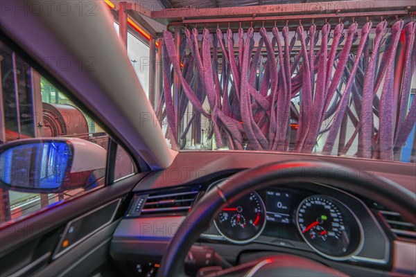 Car in an automatic car wash, car wash tunnel, vehicle drying after washing with warm compressed