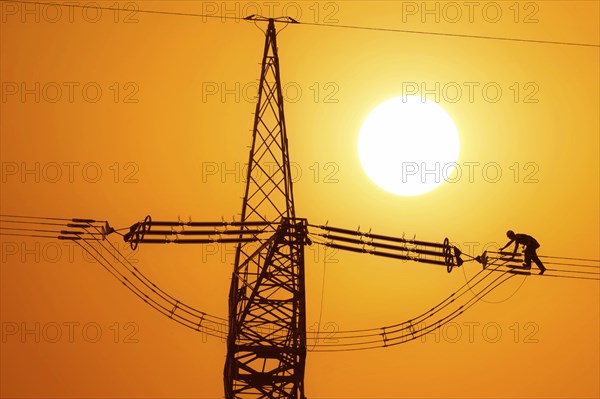 Photomontage, overhead line fitter working on a high-voltage pylon, overhead lines, energy, worker,