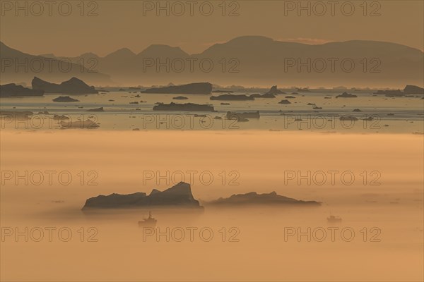 Boats in front of icebergs in the fog, midnight sun, summer, Ilulissat, Ilulissat Icefjord, Disko