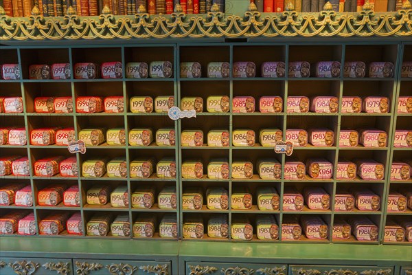 A shelf in the shop stocked with many tins of sardines in different colours and designs, giving a
