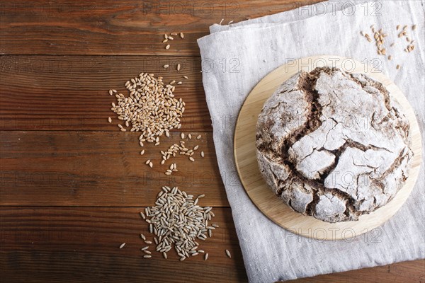 Yeast free homemade bread with whole rye and wheat grains on rustic wooden background. Top view,