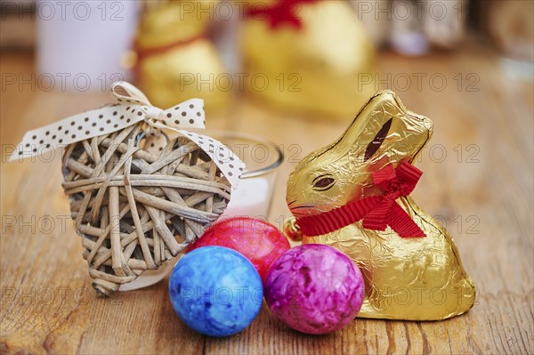 Decoration with colourful eggs and golden chocolate bunnies for easter, Germany, Europe