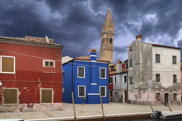 Colourful residential buildings, behind the leaning tower of the church of St. Martin Vescovo, 16th