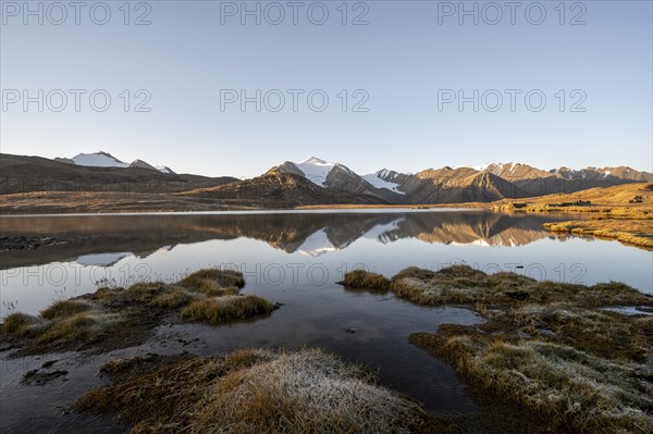 Glaciated mountain peaks reflected in a mountain lake at sunset, Arabel Lake at Arabel Pass, Issyk