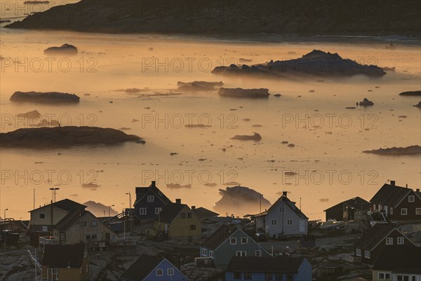 Inuit settlement in front of icebergs in the fog, midnight sun, summer, Ilulissat, Ilulissat