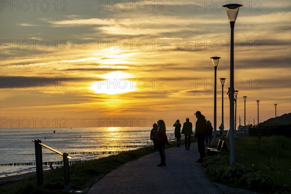 Sunset on the beach of Zoutelande, people on the dike, Zeeland, Netherlands