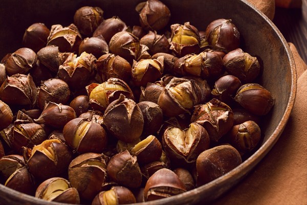 Roasted chestnuts, in an iron pan, wooden table, top view, no people, rustic style
