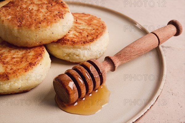 Cottage cheese pancakes, with honey, close-up, on a beige table, selective focus, no people